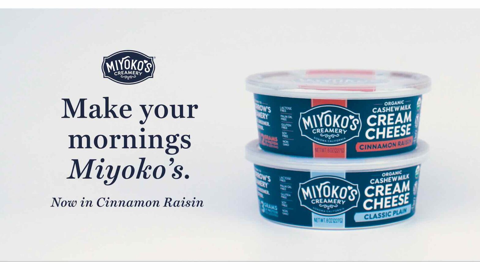 Two tubs of Miyoko's Creamery Cashew Milk Cream Cheese, one in Cinnamon Raisin flavor and the other in Classic Plain, are stacked. Text reads: "Make your mornings Miyoko's. Now in Cinnamon Raisin." Experience the magic through innovative content marketing.